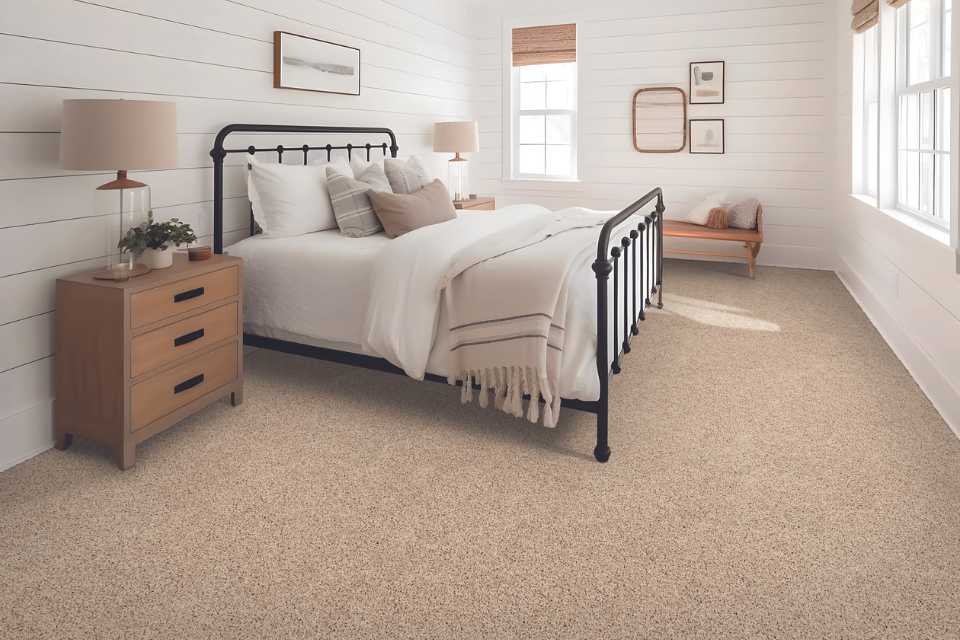 plush soft beige carpet in simple cabin bedroom with white shiplap walls and wood accents